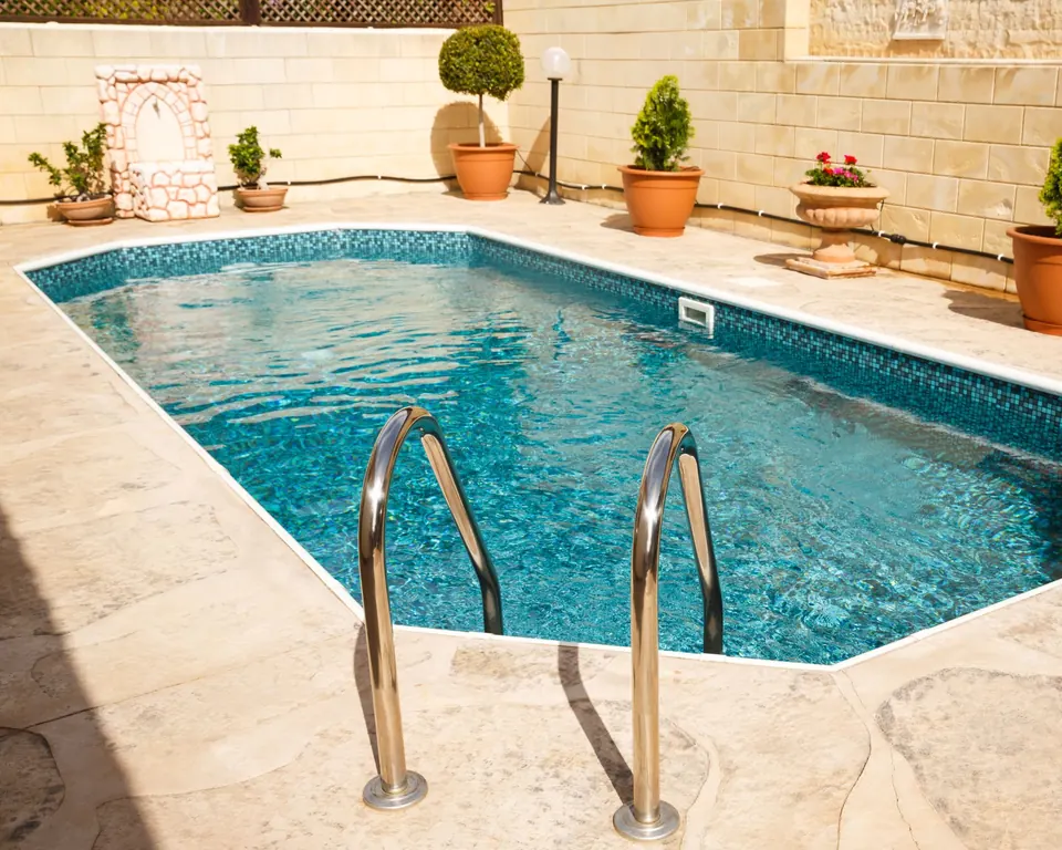 Piscine entourée d'un dallage en pierre beige, réalisation Dekorenov